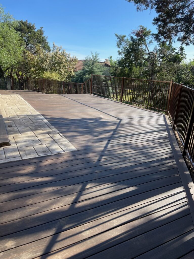 Large stained wood deck with metal railing built in Central Texas