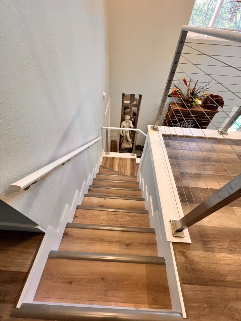 Staircase rebuild with wood treads and cable railing in progress