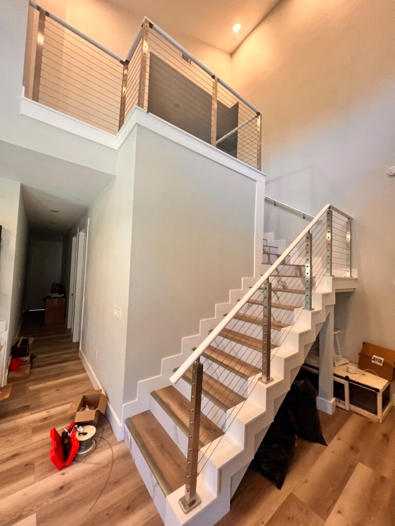 Interior staircase with wood treads and cable railing, custom carpentry in Austin