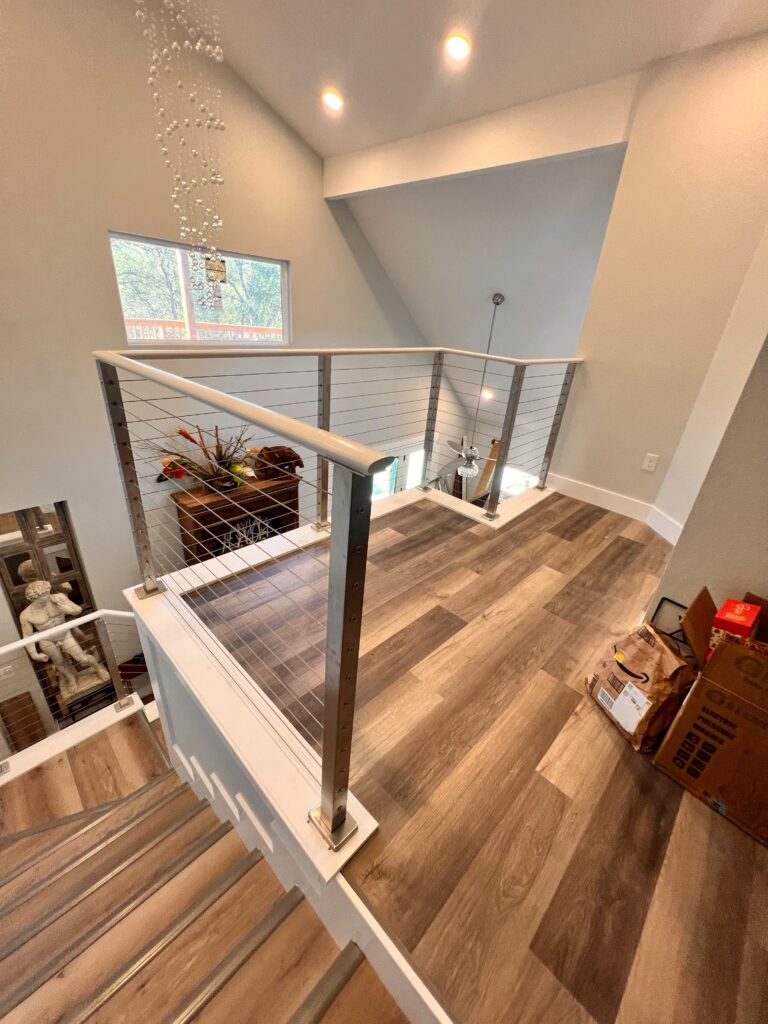 Cable stair railing and wood flooring installed on an upstairs landing